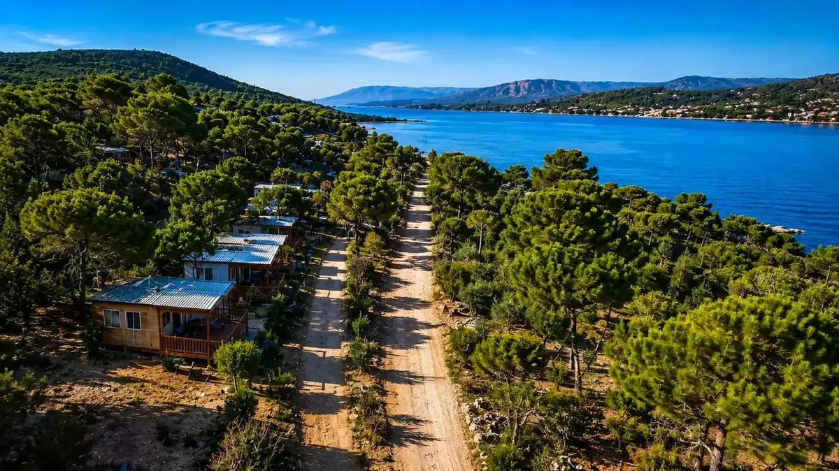 Camino de acceso a un camping junto al mar entre pinos